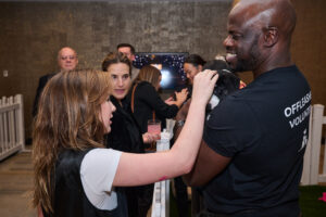A woman petting a puppy held by a volunteer at BC SPCA's Offleashed Vancouver Gala 2023