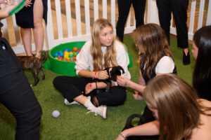 A child woman holding a puppy at the Cuddle Lounge at BC SPCA's Offleashed Vancouver Gala 2023
