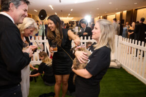 Guests engaging with a volunteer holding a puppy at BC SPCA's Offleashed Vancouver Gala 2023