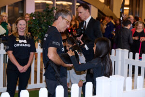 A child petting a puppy at BC SPCA's Offleashed Vancouver Gala 2023