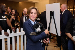 A child holding a puppy at BC SPCA's Offleashed Vancouver Gala 2023
